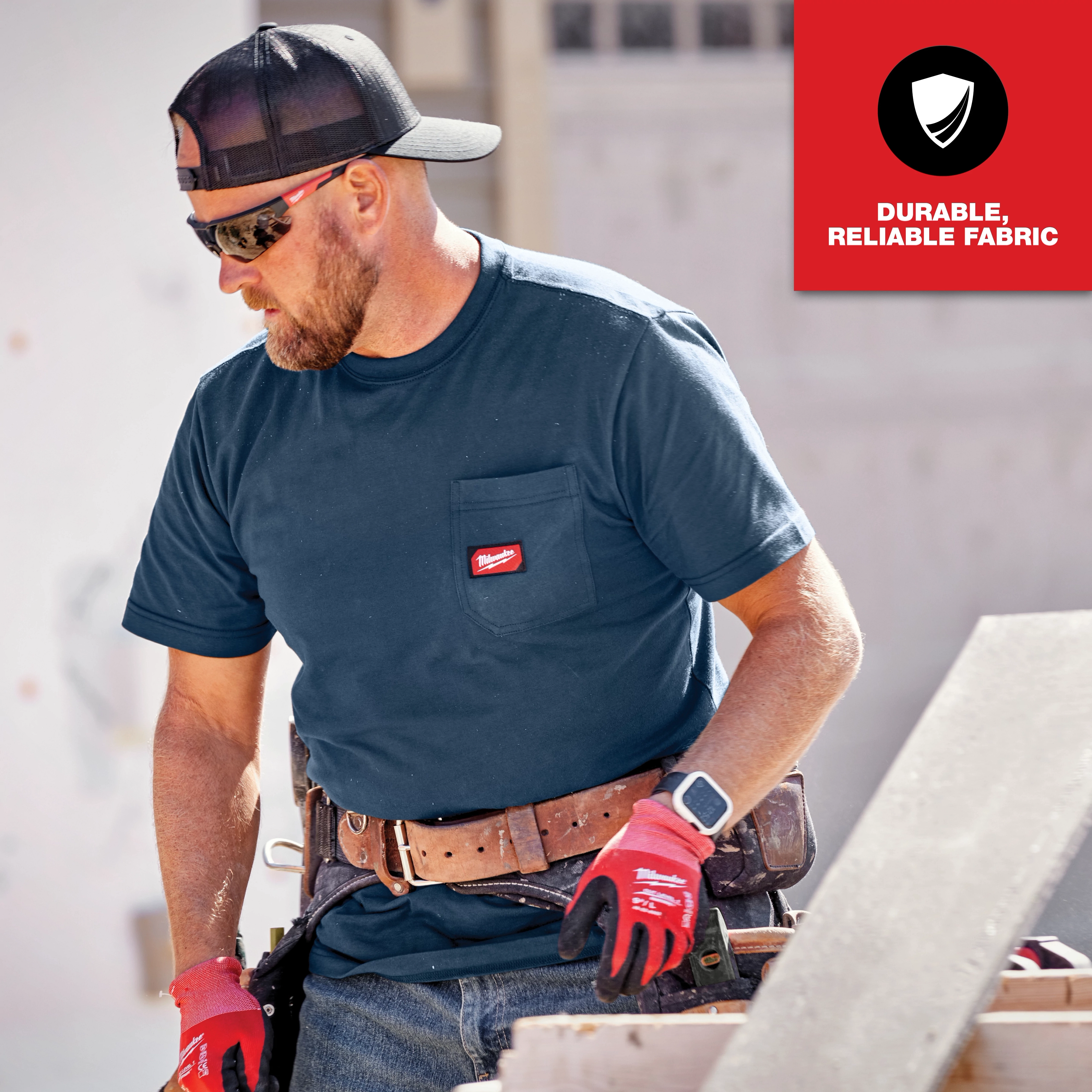 Man wearing a navy blue GRIDIRON Pocket T-Shirt - Short Sleeve with a chest pocket label, working on a construction site.