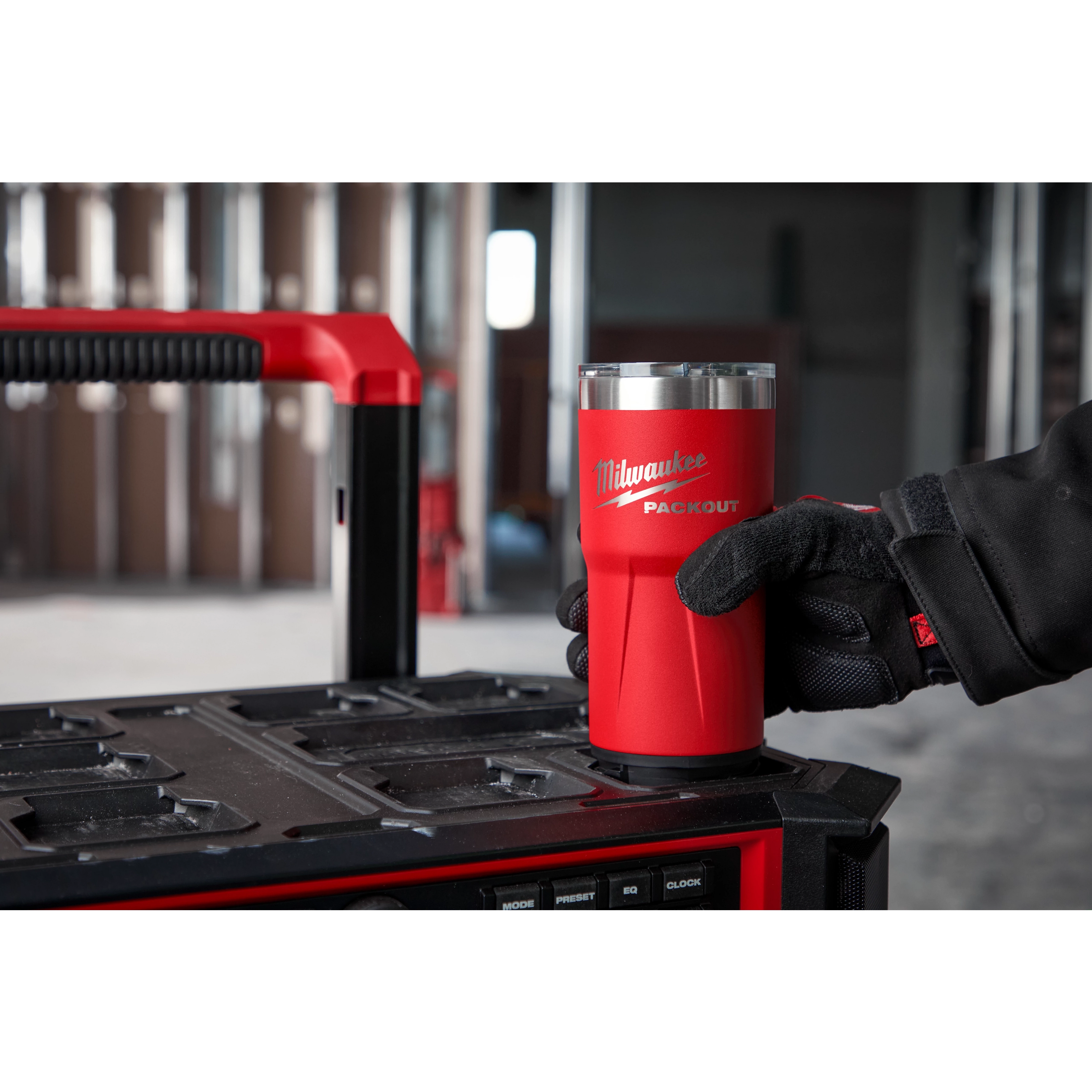 Worker twist locking the PAKCOUT Tumbler in the cup holder on top of the PACKOUT Cooler