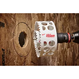 The image shows a Hole Enlargement Adapter for QUIK-LOK™ Arbor attached to a drill, cutting a larger hole in a wooden surface. The adapter, labeled "HOLE DOZER," is designed to increase the diameter of existing holes.