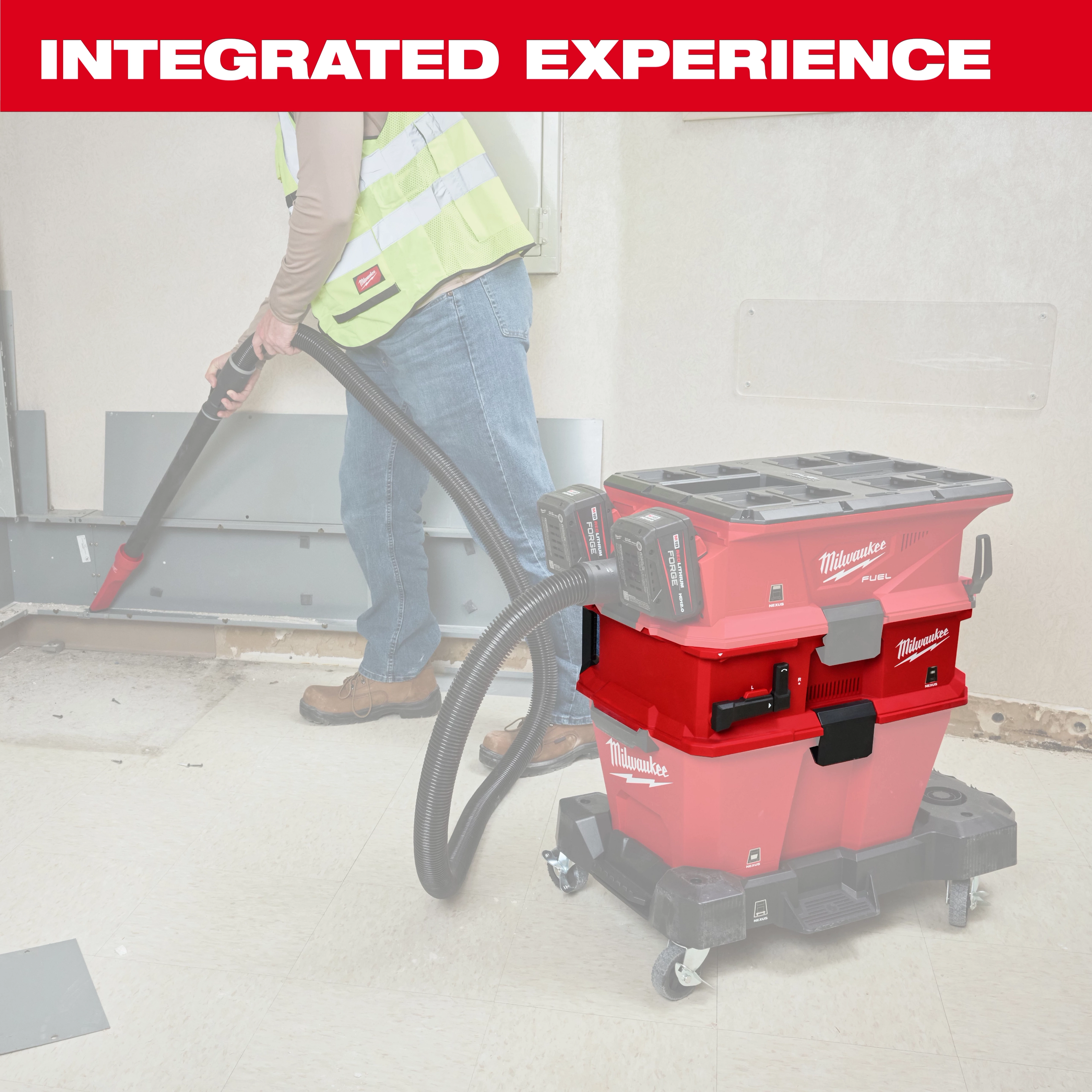 The NEXUS™ Dedicated Filter Cleaner is a red, portable cleaning unit on wheels, designed for efficient filter cleaning. It features attachable hoses and dual battery packs. A person wearing a high-visibility vest is seen using the cleaner in a construction setting.