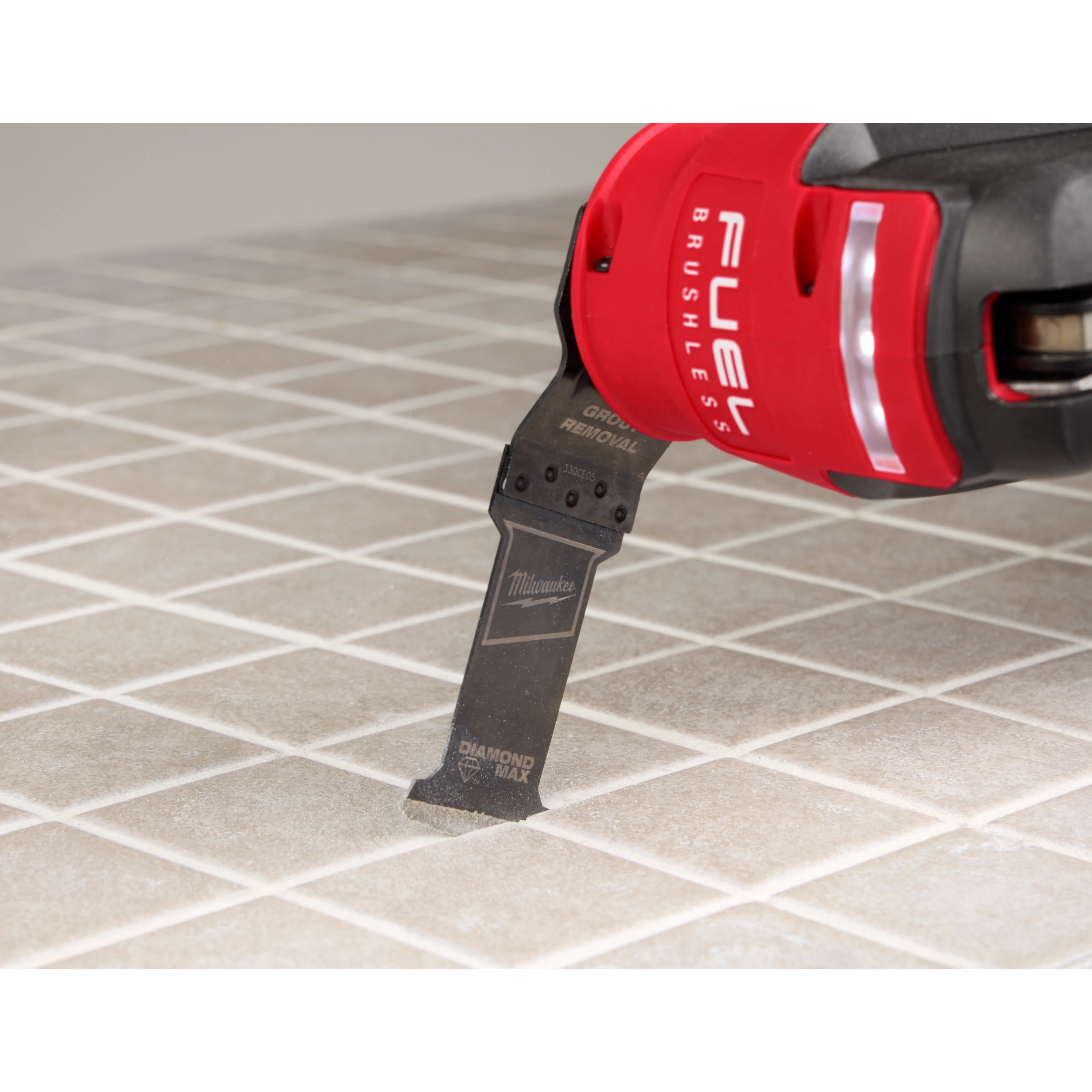 Image of the OPEN-LOK™ DIAMOND MAX™ Diamond Grit Grout Removal Multi-Tool Plunge Blade being used in a Milwaukee Multi-Tool on tile
