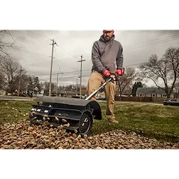 Worker using the M18 FUEL QUIK-LOK Rubber Broom Attachment