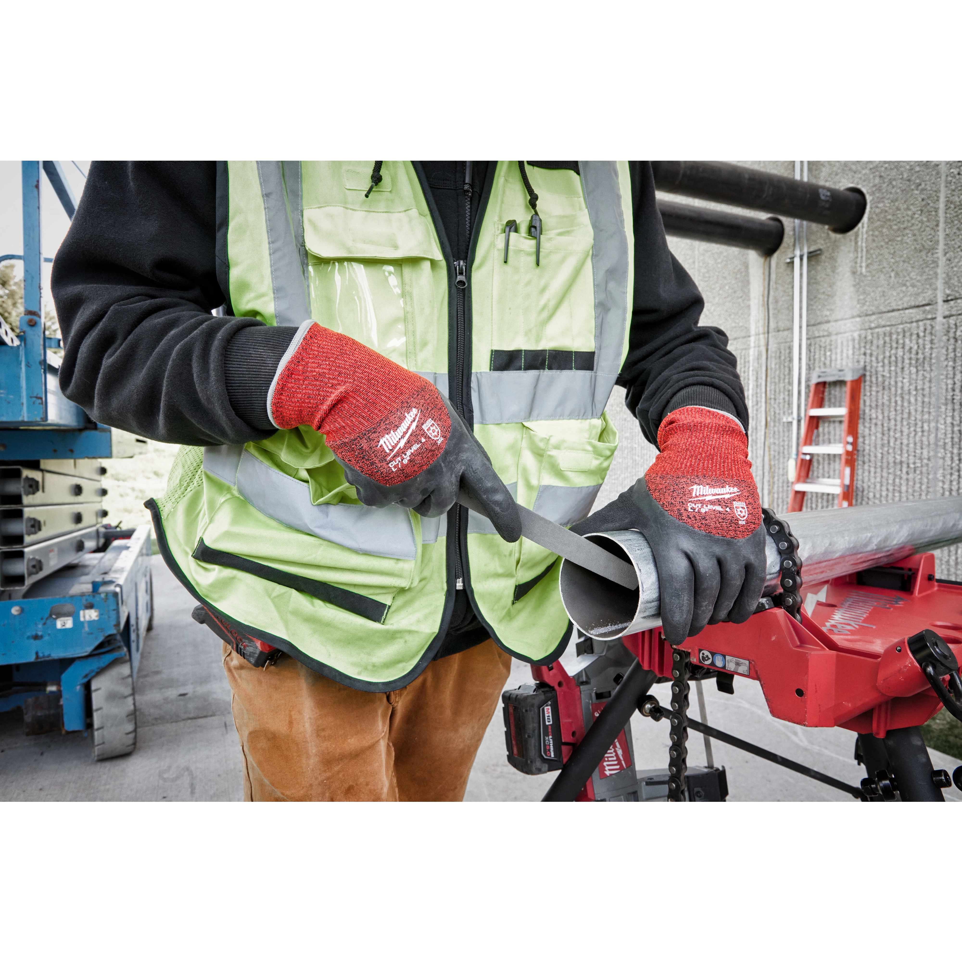 Person wearing Cut Level 4 Winter Dipped Gloves - L working on a metal pipe outdoors, using a hand file for deburring.