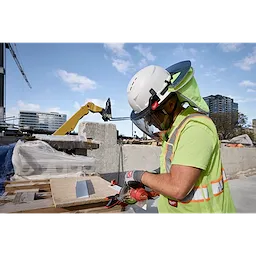 A construction worker wearing a BOLT 4PT White Full Brim Vented Safety Helmet - Type 2, Class C, operating a tool at a construction site.