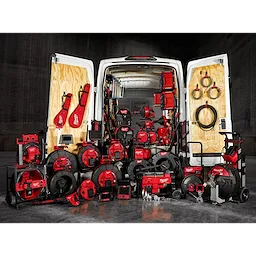 The image shows a van with its rear doors open, revealing a wide array of red and black sewer and drain cleaning equipment arranged both inside and in front of the van. The tools are part of the January 2025 Sewer & Drain Cleaning Family collection.