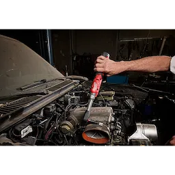 M12 FUEL 1/2" Extended Reach Ratchet being used to work on a car engine in a garage.