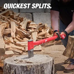 Person in gloves splitting wood with a 36-inch splitting axe. The axe has a red handle and is in action on a tree stump.