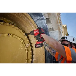 Worker using an M18 FUEL 3/4" Extended Anvil High Torque Impact Wrench w/ ONE-KEY on a large industrial wheel.