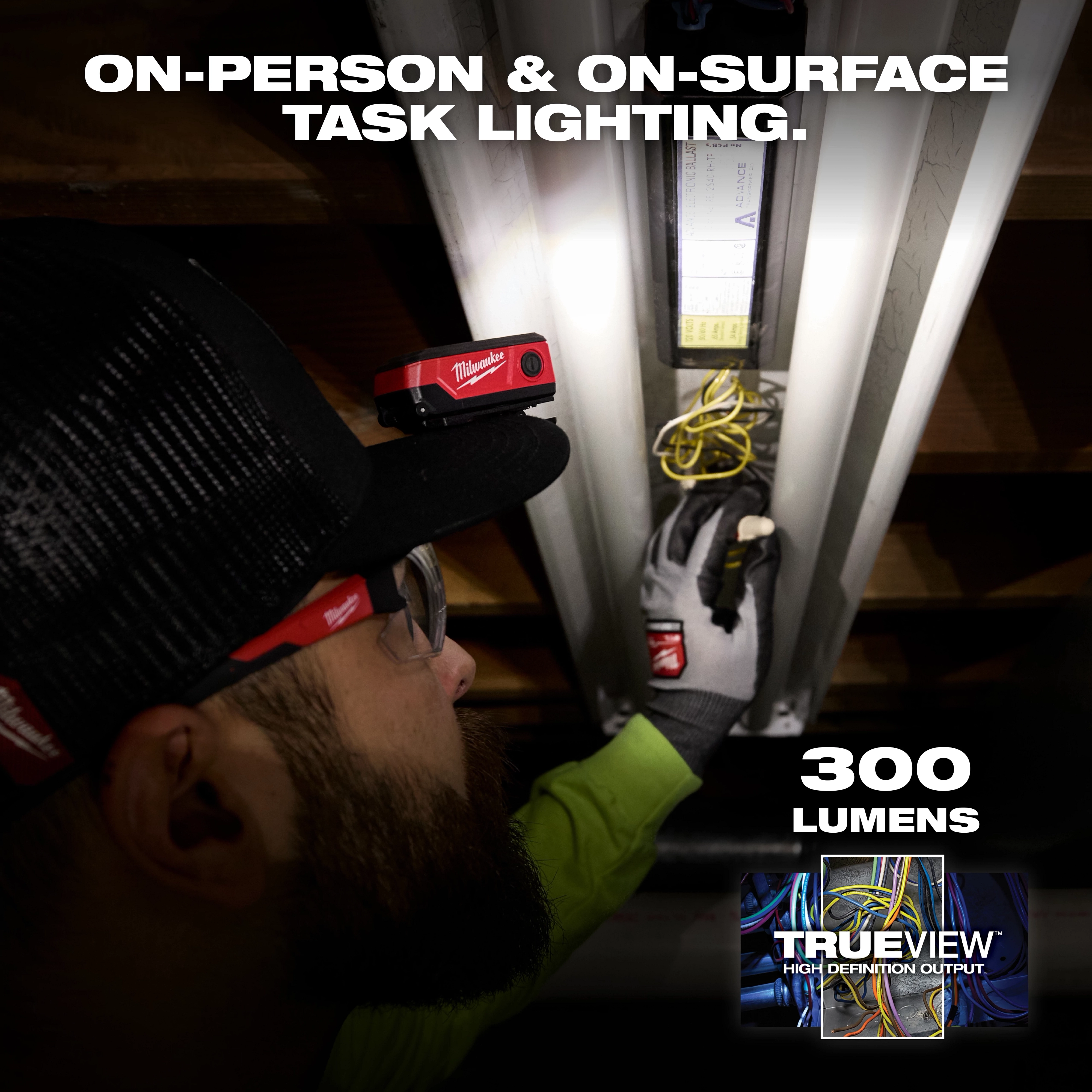 Worker using a Milwaukee Rechargeable Clip Light on a hat while wiring a ceiling fixture indoors.
