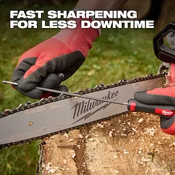 Close-up of hands wearing red and black gloves using a Chain Sharpening tool on a chainsaw blade. The image features the text "Fast sharpening for less downtime" and shows wood shavings on a tree stump in the background.