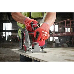 Person wearing Cut Level 2 Nitrile Dipped Gloves - L operating a circular saw to cut a piece of wood in a workshop.