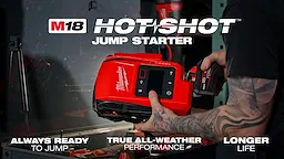The video shows an M18™ HOTSHOT™ Jump Starter, a red portable device with black and copper clamps attached. It features a prominent Milwaukee® logo, an LED light on the front, and several indicator icons and buttons on the top.