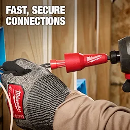 A worker uses the Milwaukee Wire Nut Twister tool to secure electrical wires. The tool is red and connected to a power drill. The person is wearing Milwaukee-branded gloves, and the background features wooden studs with blue electrical boxes. Text reads: "Fast, Secure Connections."