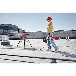 Worker carrying the M18 FUEL Pipe Threader on the jobsite