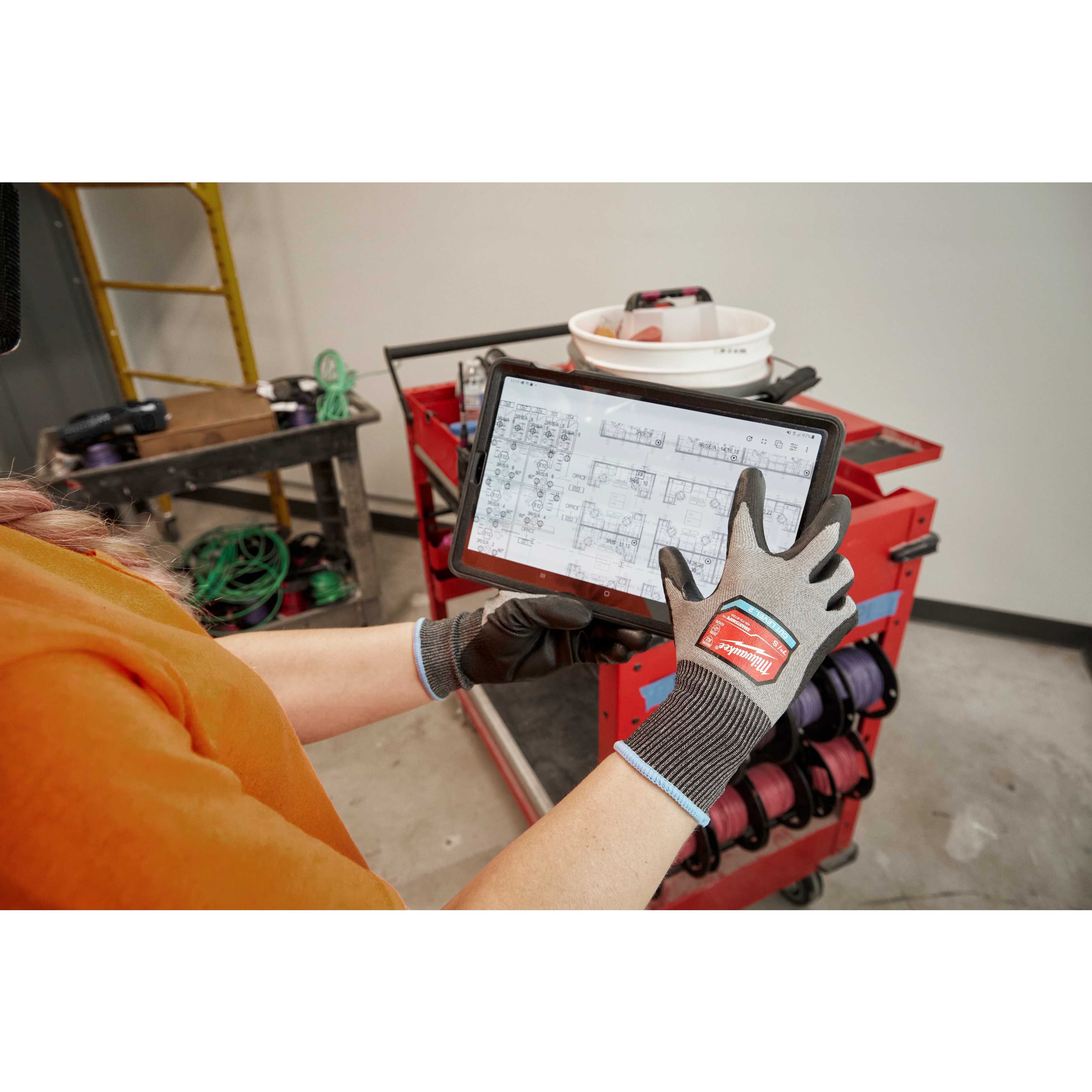 Worker wearing the Cut 2 High-Dexterity Gloves while using a tablet
