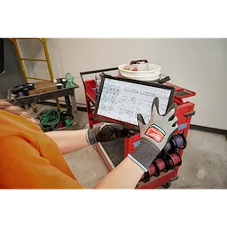 Worker wearing the Cut 2 High-Dexterity Gloves while using a tablet