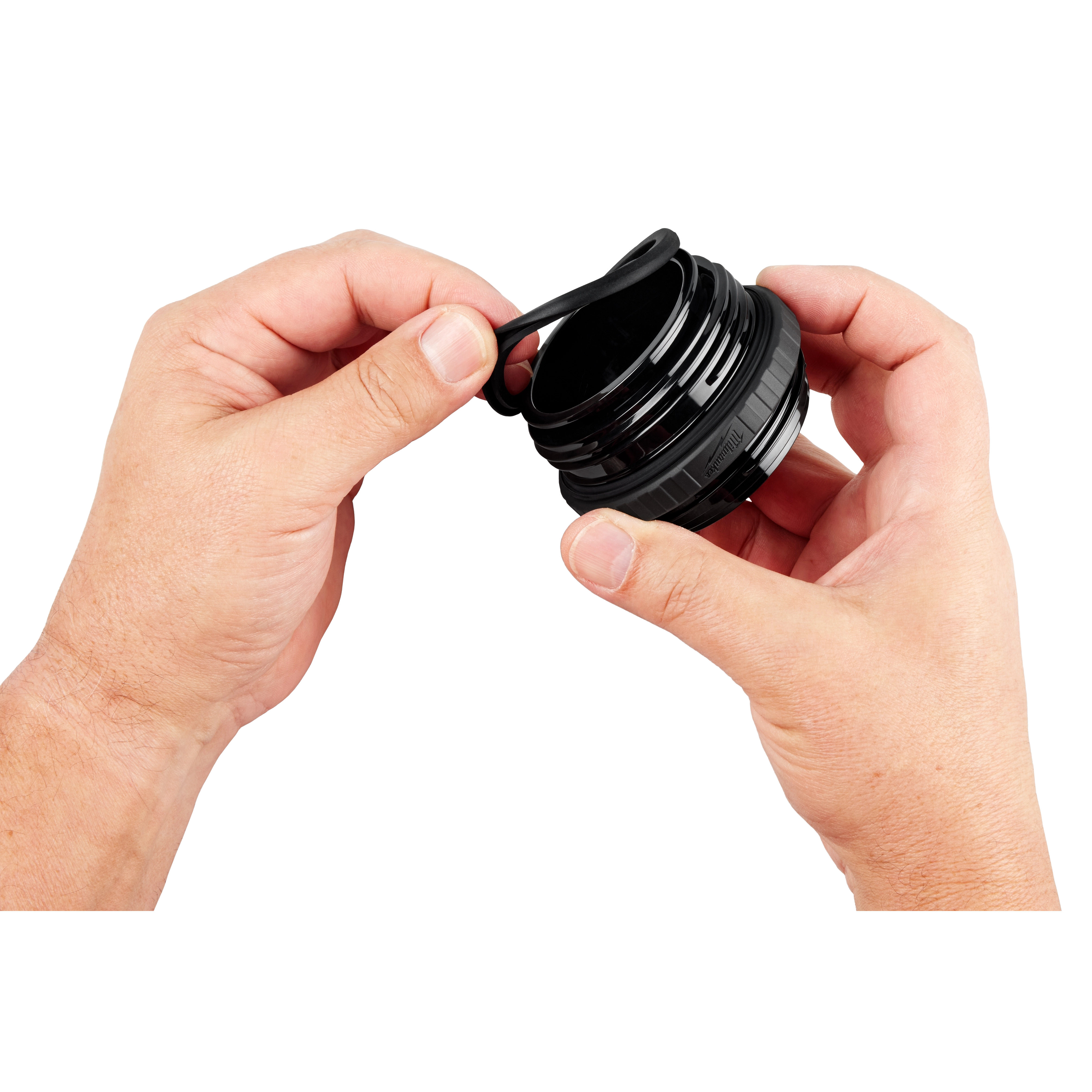 Hands holding the PACKOUT Sip Lid, a black, cylindrical lid with a small spout, designed for easy drinking and security.