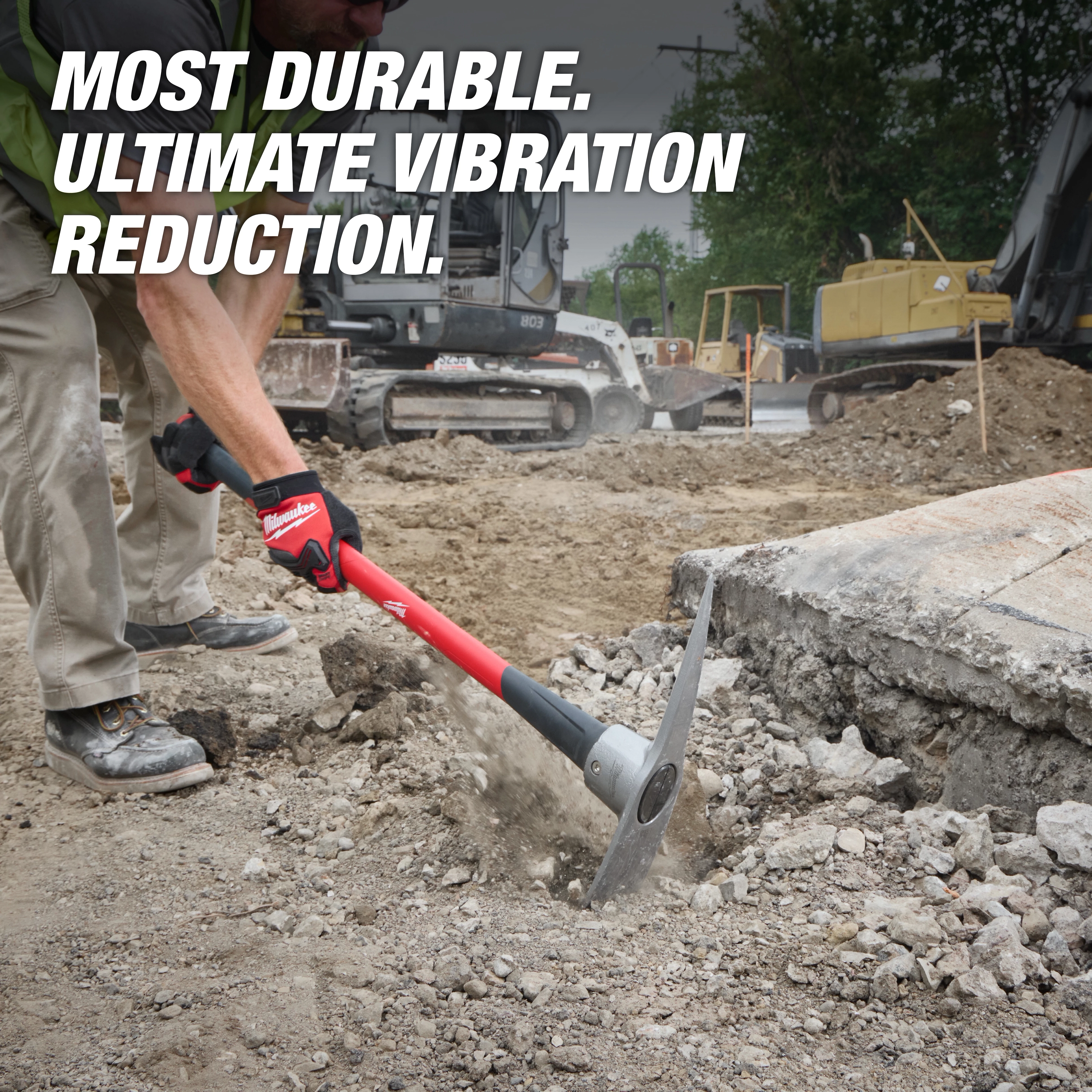 Worker using a 5lb Pick Mattock (36" Handle) to break ground at a construction site. Text reads "MOST DURABLE. ULTIMATE VIBRATION REDUCTION."