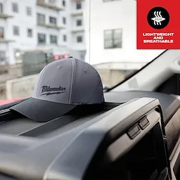 WORKSKIN Performance Fitted Hat in dark gray with black brim on car dashboard. Text overlay reads “Lightweight and Breathable.”