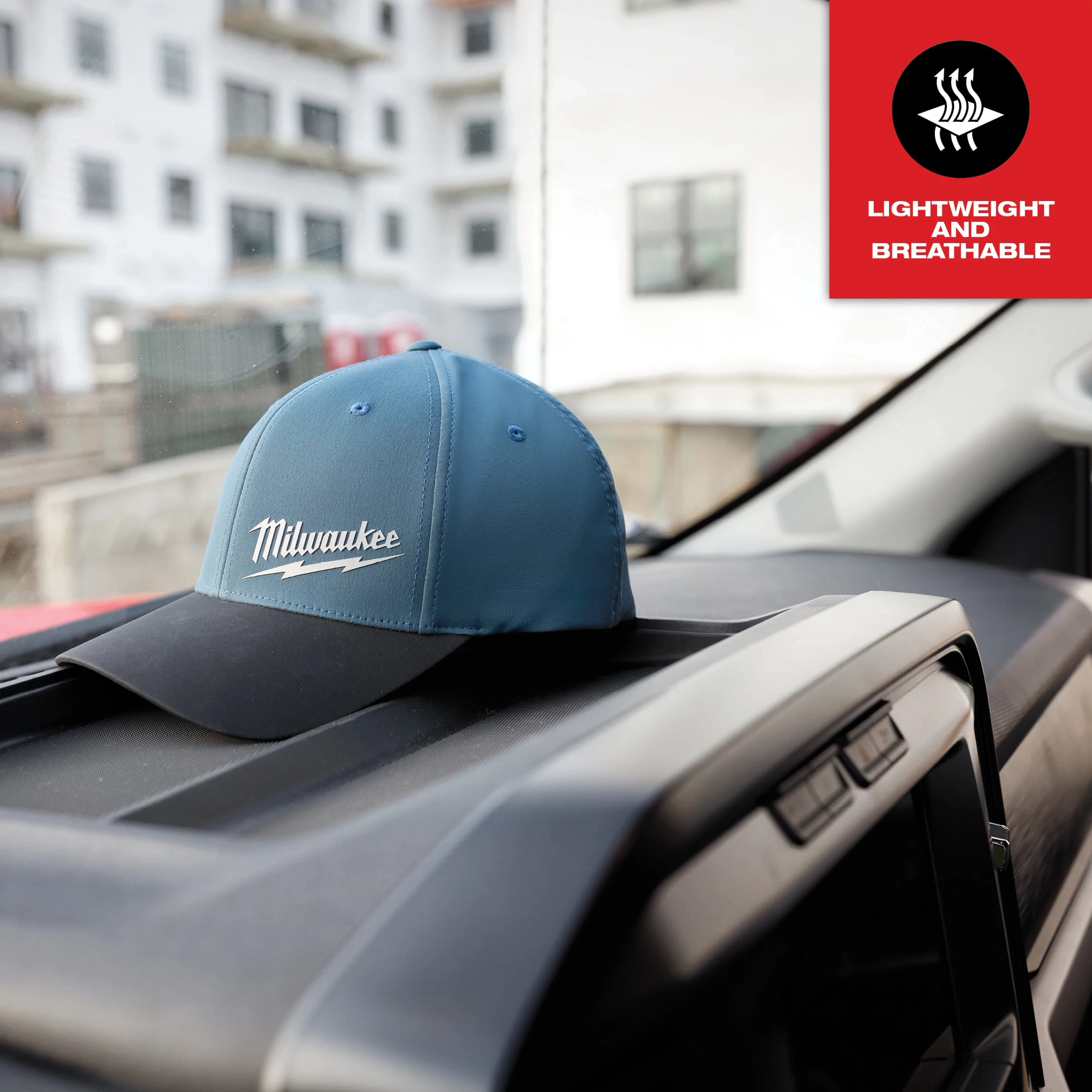WORKSKIN Performance Fitted Hat in blue displayed on a vehicle dashboard, with a "Lightweight and Breathable" label in the corner.