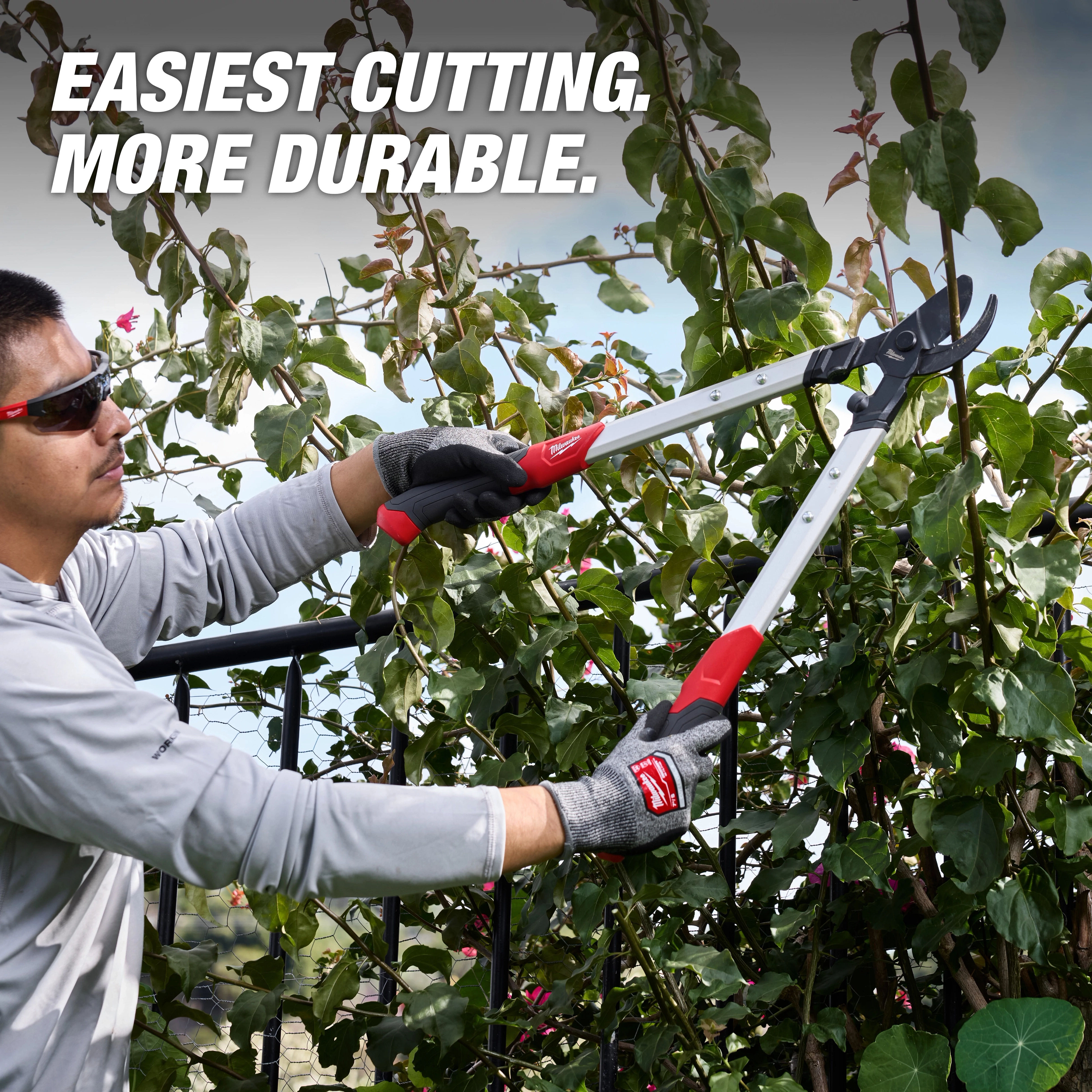 Person trimming leafy branches with a 1-1/2” Lopper​ featuring long handles and cushioned grips.