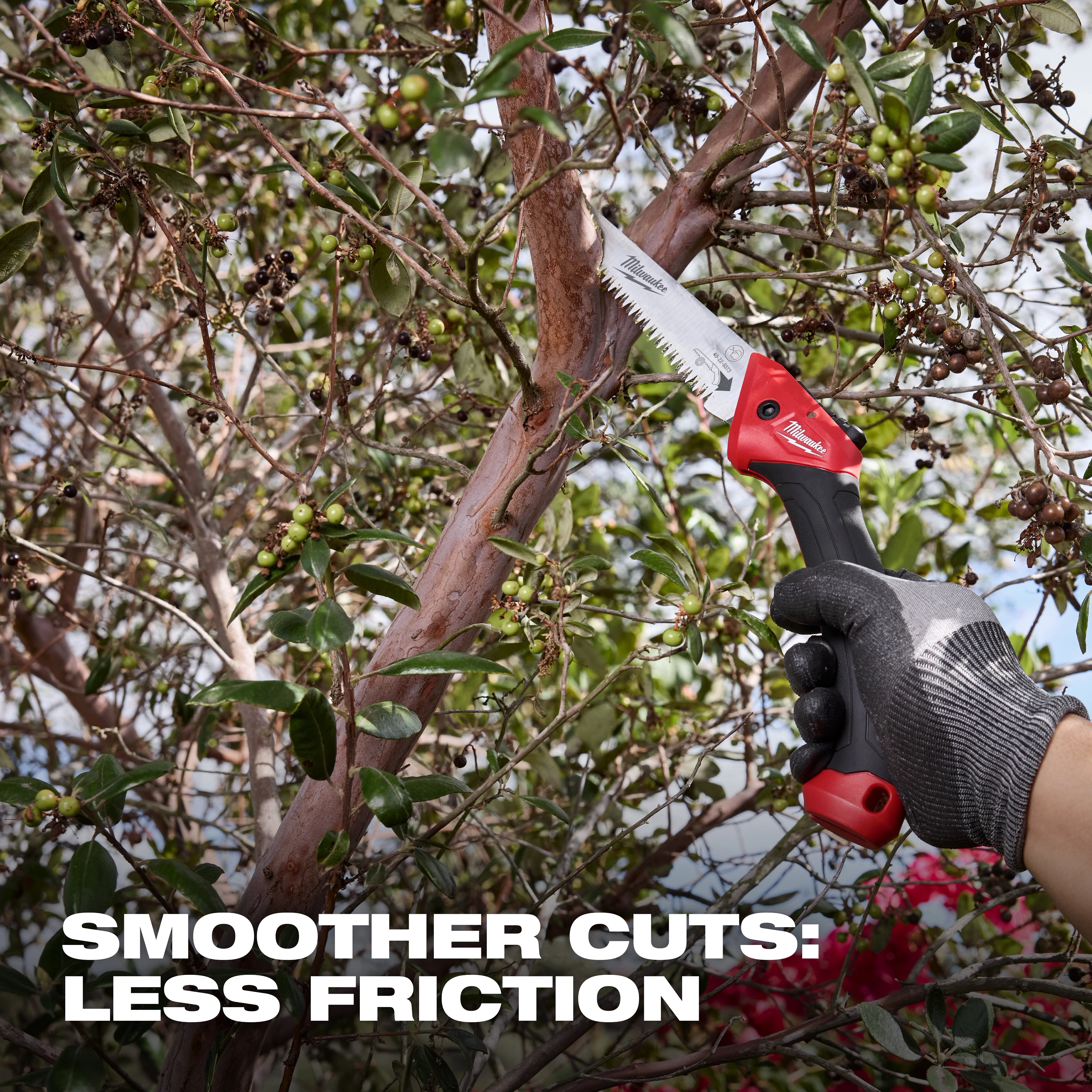 7” Folding Pruning Saw – Straight Blade cutting a tree branch, held by a gloved hand among dense foliage.