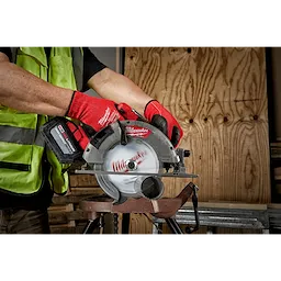 Worker using a 7-1/4" Metal Cutting Circular Saw Blade, 5/8" Arbor, on a saw for cutting metal sheets in a workshop.