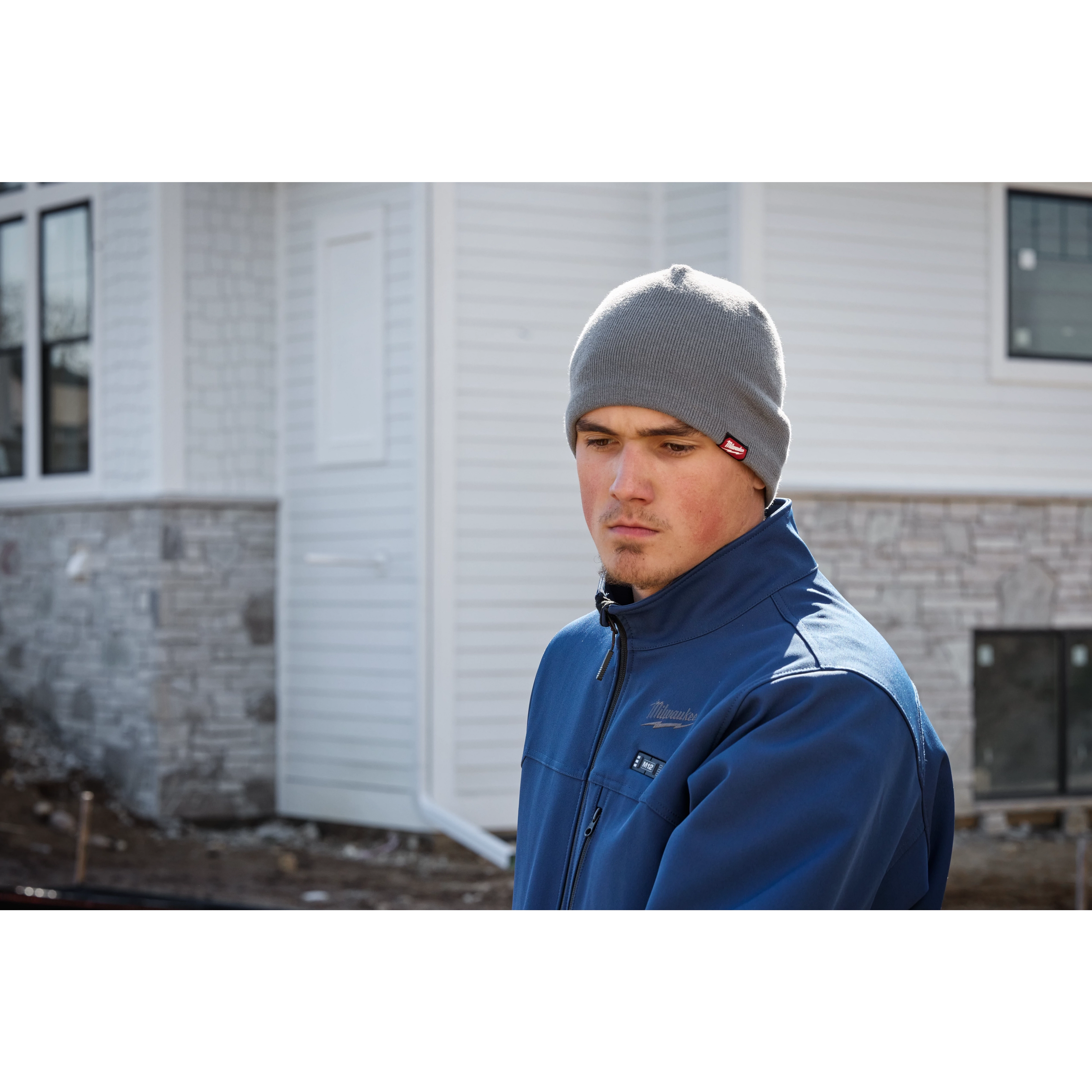 Image of a man on a jobsite wearing the Milwaukee Fleece-Lined Beanie in gray