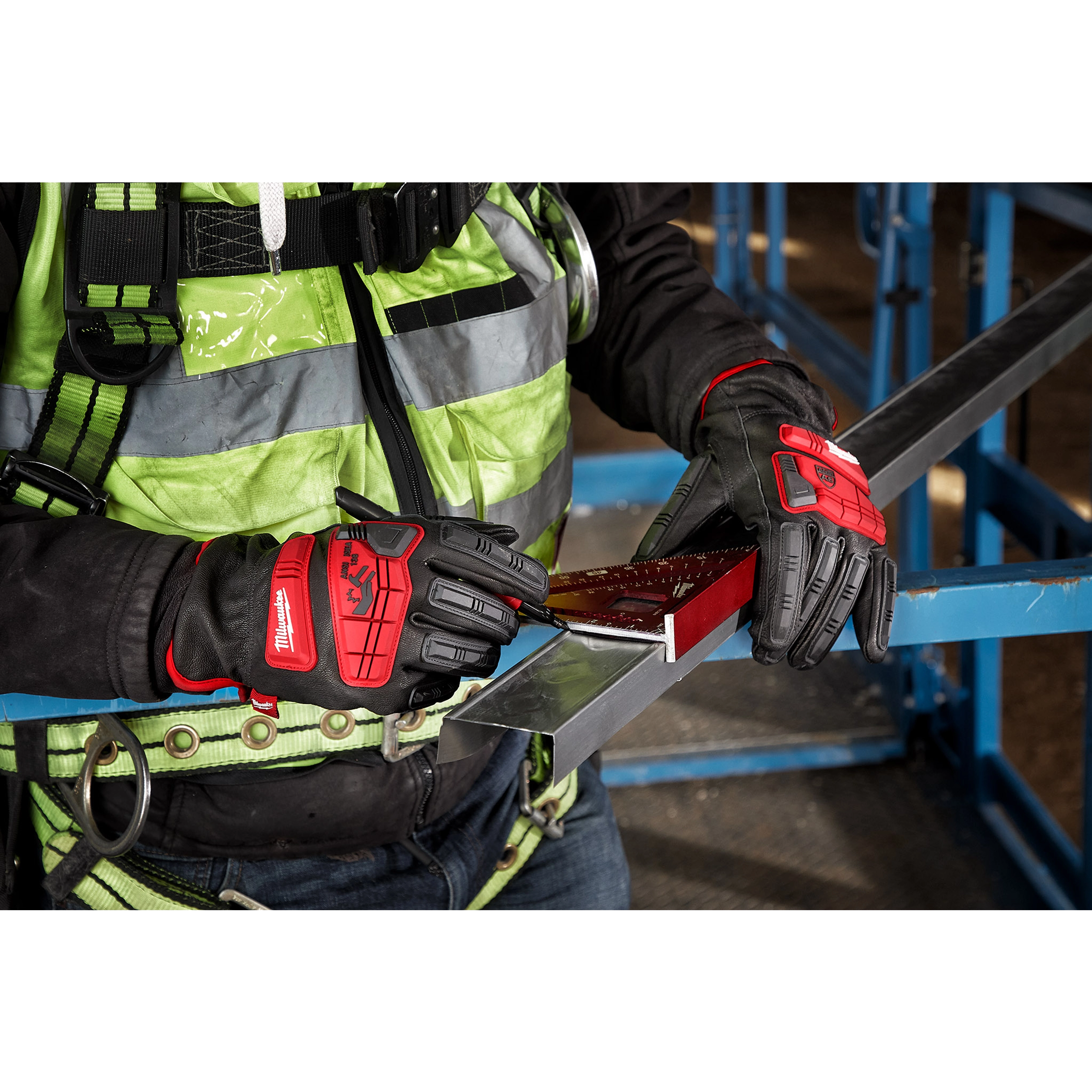 Person wearing Impact Cut Level 5 Goatskin Leather Gloves holding a metal sheet and measuring tool at a construction site.